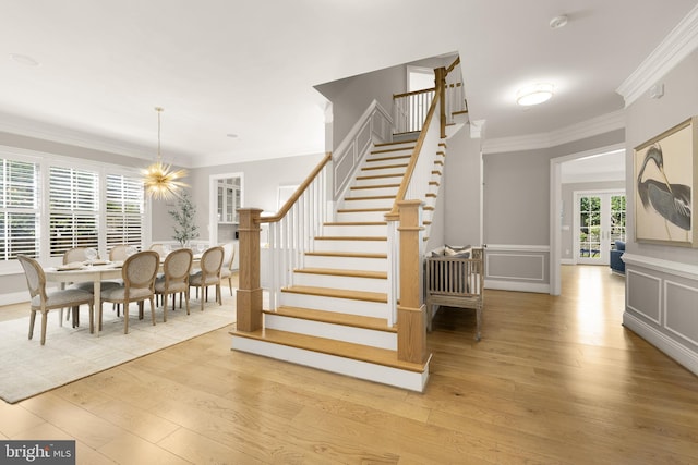 5606 Parkston Rd, Bethesda, MD 20816 - stairway with wood finished floors, crown molding, wainscoting, and a chandelier