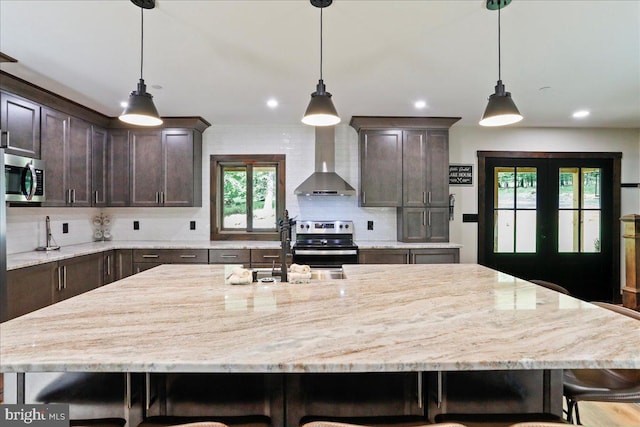130 Lodestone Way, Mc Henry, MD 21541 - kitchen with wall chimney exhaust hood, stainless steel appliances, dark brown cabinets, a breakfast bar area, and tasteful backsplash
