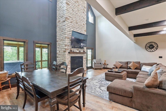 130 Lodestone Way, Mc Henry, MD 21541 - dining room with a fireplace, beam ceiling, a high ceiling, and light wood-style floors
