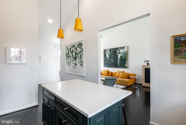 1823 Belmont Rd NW Unit D, Washington, DC 20009 - kitchen with high vaulted ceiling, light countertops, dark wood finished floors, a kitchen island, and decorative light fixtures