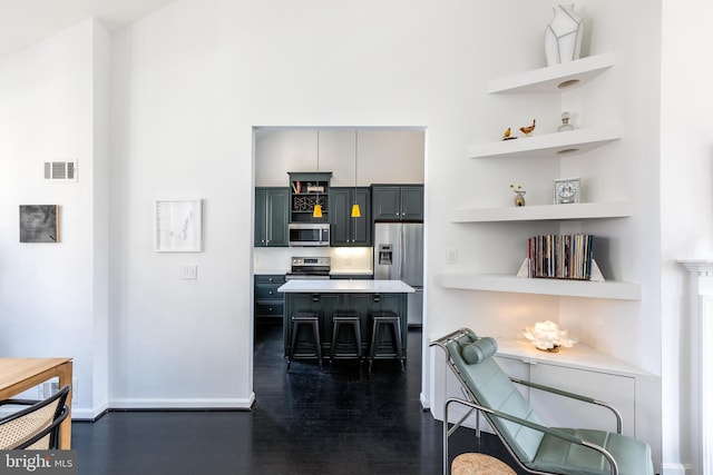 1823 Belmont Rd NW Unit D, Washington, DC 20009 - kitchen with stainless steel appliances, open shelves, dark wood finished floors, a breakfast bar, and light countertops