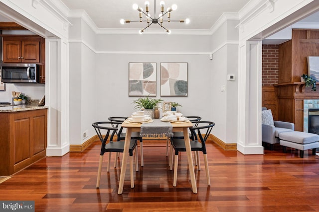 1013 S Decker Ave, Baltimore, MD 21224 - dining room with dark wood-style flooring, ornamental molding, a chandelier, and a glass covered fireplace