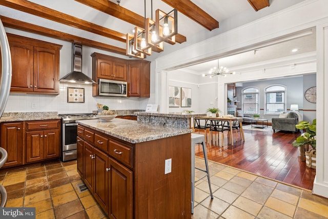 1013 S Decker Ave, Baltimore, MD 21224 - kitchen with wall chimney range hood, stainless steel appliances, a chandelier, a kitchen breakfast bar, and a center island