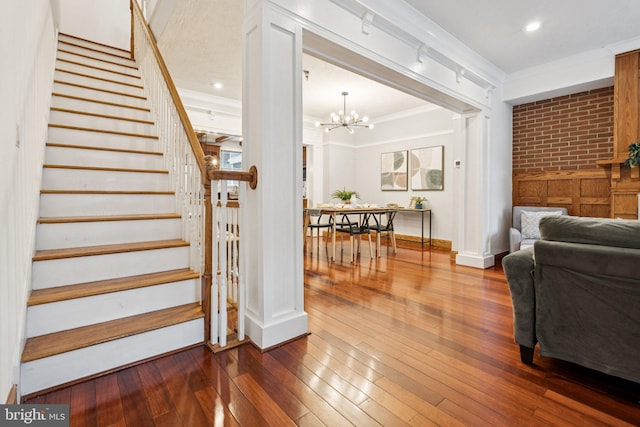 1013 S Decker Ave, Baltimore, MD 21224 - staircase with ornamental molding, wood-type flooring, a chandelier, brick wall, and recessed lighting