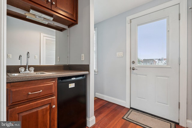 1013 S Decker Ave, Baltimore, MD 21224 - kitchen featuring black dishwasher, dark wood finished floors, dark countertops, and brown cabinetry