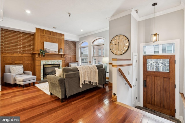 1013 S Decker Ave, Baltimore, MD 21224 - living room with ornamental molding, dark wood-style flooring, a tile fireplace, and recessed lighting