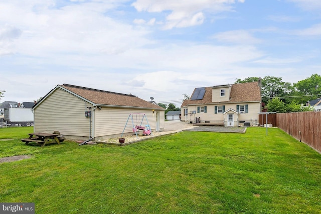 207 E Main St, Penns Grove, NJ 08069 - rear view of house with a patio, a fenced backyard, an outbuilding, and solar panels