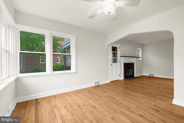 204 Opal Ave, Reading, PA 19606 - unfurnished living room featuring arched walkways, wood finished floors, ceiling fan, and a fireplace with flush hearth