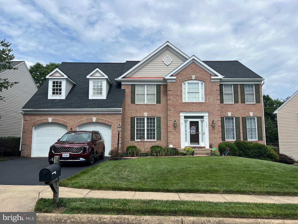 13508 Wembley Loop, Bristow, VA 20136 - colonial inspired home with brick siding, a front yard, driveway, and roof with shingles