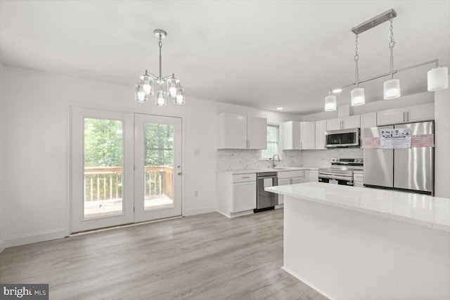 95 Arthur Burke Ln, Front Royal, VA 22630 - kitchen with appliances with stainless steel finishes, a chandelier, backsplash, light wood-style flooring, and white cabinetry