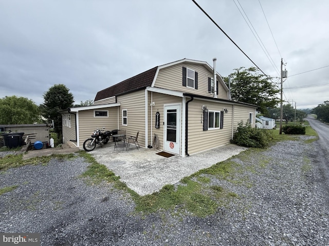134 Catlett Mountain Rd, Front Royal, VA 22630 - back of property featuring a gambrel roof, a patio area, and roof with shingles