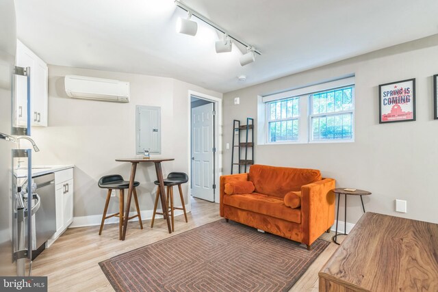 459 Massachusetts Ave NW Unit B1, Washington, DC 20001 - living room featuring a wall mounted AC, track lighting, light wood finished floors, and electric panel