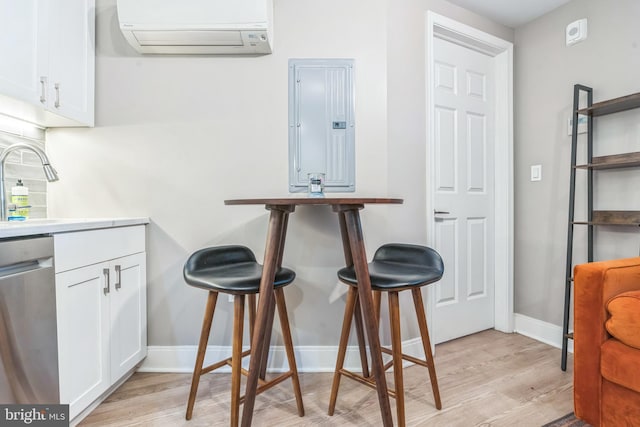 459 Massachusetts Ave NW Unit B1, Washington, DC 20001 - kitchen featuring an AC wall unit, electric panel, dishwasher, and light wood-style flooring