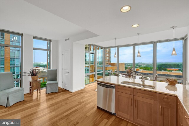 11990 Market St Unit 907, Reston, VA 20190 - kitchen featuring dishwasher, light wood-style floors, light stone counters, a wall of windows, and pendant lighting