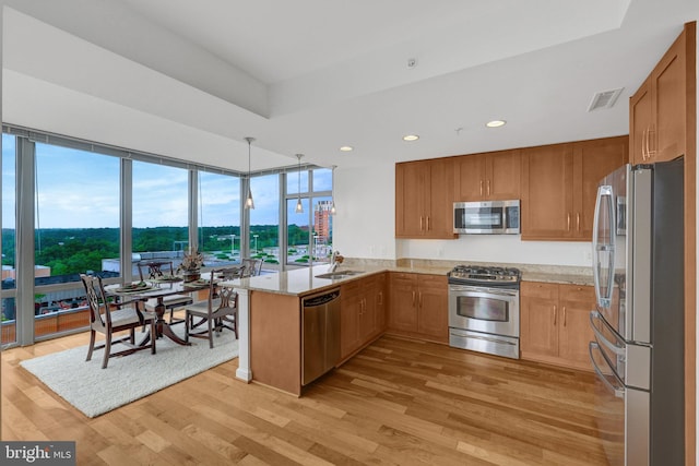 11990 Market St Unit 907, Reston, VA 20190 - kitchen featuring stainless steel appliances, a peninsula, light stone countertops, light wood finished floors, and recessed lighting