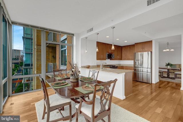 11990 Market St Unit 907, Reston, VA 20190 - dining room featuring light wood-style floors, a wall of windows, a chandelier, and recessed lighting
