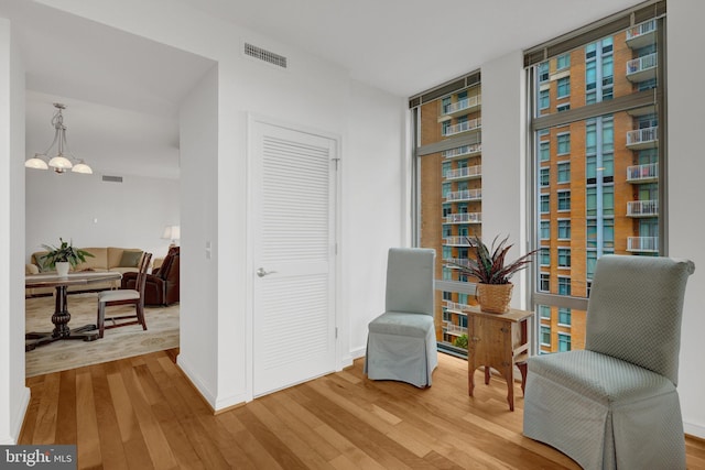 11990 Market St Unit 907, Reston, VA 20190 - living area with wood finished floors, a chandelier, and a wall of windows
