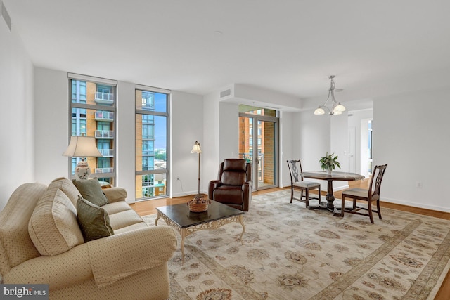 11990 Market St Unit 907, Reston, VA 20190 - living room featuring healthy amount of natural light, wood finished floors, and a chandelier