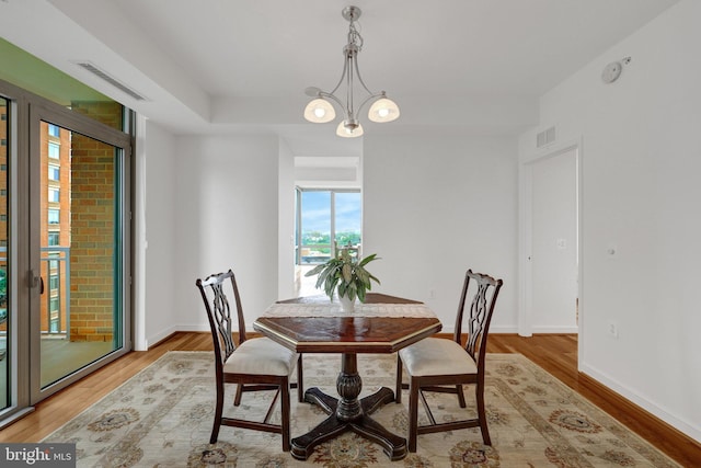 11990 Market St Unit 907, Reston, VA 20190 - dining space featuring light wood-style flooring and a chandelier
