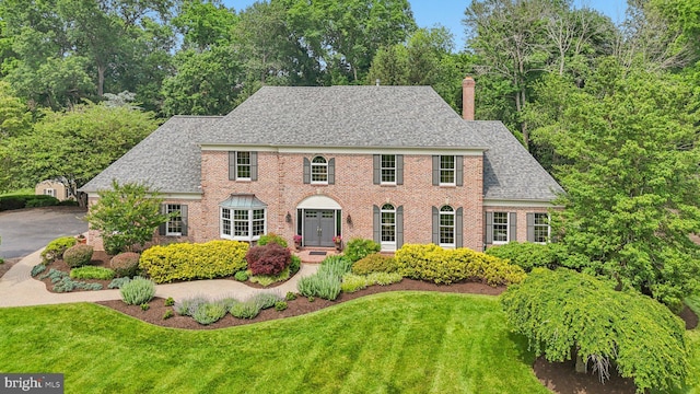 660 Casey Ln, West Chester, PA 19382 - georgian-style home with a front yard, a chimney, roof with shingles, and brick siding