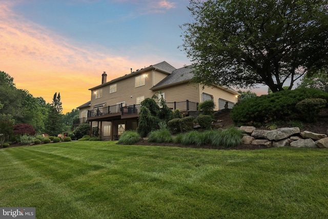 660 Casey Ln, West Chester, PA 19382 - back of property at dusk featuring a yard, a chimney, and a wooden deck