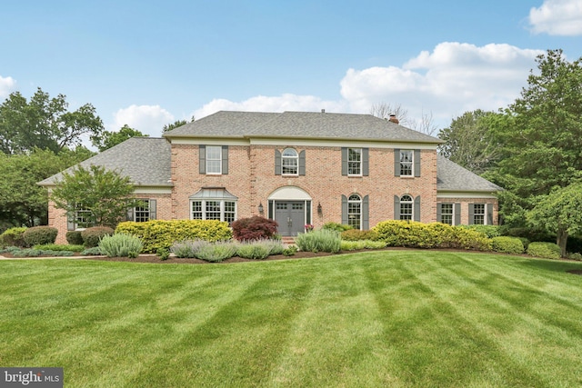 660 Casey Ln, West Chester, PA 19382 - colonial home featuring brick siding, a front yard, a chimney, and roof with shingles