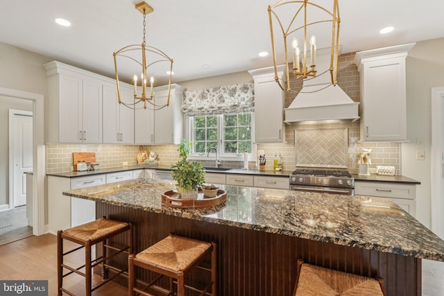 660 Casey Ln, West Chester, PA 19382 - kitchen featuring gas stove, a chandelier, light wood-style flooring, decorative backsplash, and white cabinetry