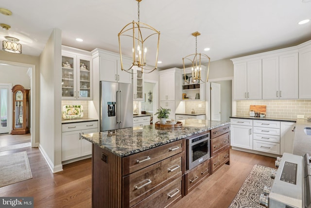 660 Casey Ln, West Chester, PA 19382 - kitchen with high quality fridge, white cabinets, glass insert cabinets, decorative backsplash, and dark wood finished floors