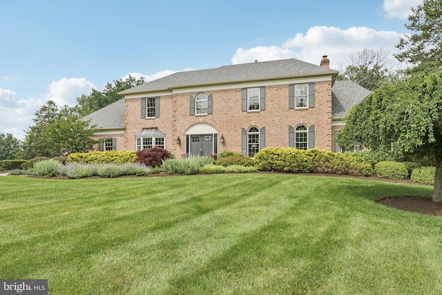 660 Casey Ln, West Chester, PA 19382 - colonial inspired home featuring a chimney, a front lawn, brick siding, and roof with shingles