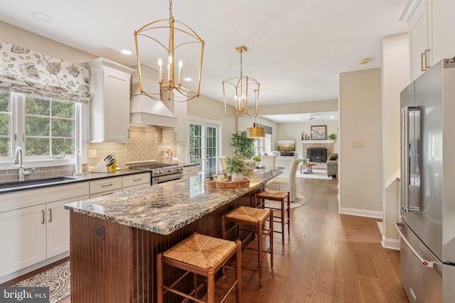 660 Casey Ln, West Chester, PA 19382 - kitchen with premium appliances, wood finished floors, a kitchen island, backsplash, and white cabinets
