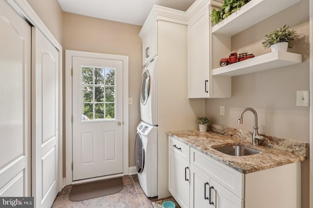 660 Casey Ln, West Chester, PA 19382 - laundry area featuring stacked washer / dryer, cabinet space, bar with sink, and light stone finish flooring