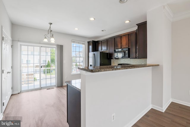 25154 Monteith Ter, Chantilly, VA 20152 - kitchen featuring black microwave, freestanding refrigerator, light wood-style floors, dark brown cabinets, and pendant lighting