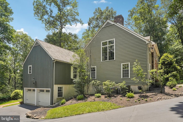 4250 Fretz Mill Rd, New Hope, PA 18938 - view of side of home with a chimney, asphalt driveway, and a garage