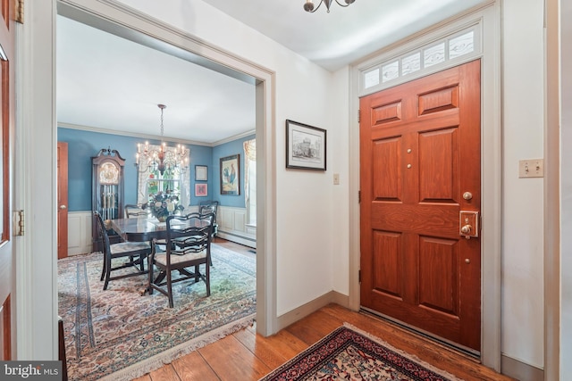 4250 Fretz Mill Rd, New Hope, PA 18938 - entrance foyer with light wood finished floors, a chandelier, a baseboard heating unit, a wainscoted wall, and crown molding