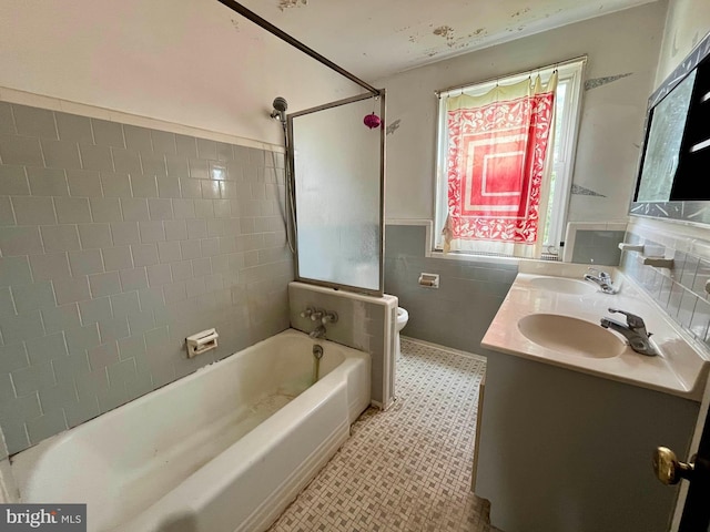 5501 W Forest Park Ave, Baltimore, MD 21207 - bathroom featuring double vanity, tile walls, and a wainscoted wall