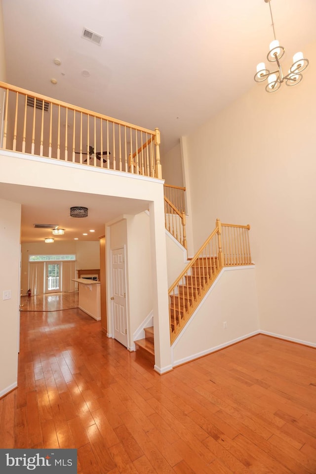 8804 Shining Oceans Way Unit 53, Columbia, MD 21045 - staircase featuring hardwood / wood-style floors, a high ceiling, and a chandelier