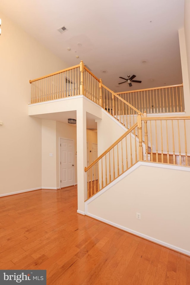 8804 Shining Oceans Way Unit 53, Columbia, MD 21045 - stairs with ceiling fan, wood finished floors, and a towering ceiling