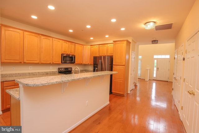 8804 Shining Oceans Way Unit 53, Columbia, MD 21045 - kitchen featuring stainless steel appliances, a center island with sink, recessed lighting, light brown cabinetry, and a breakfast bar area