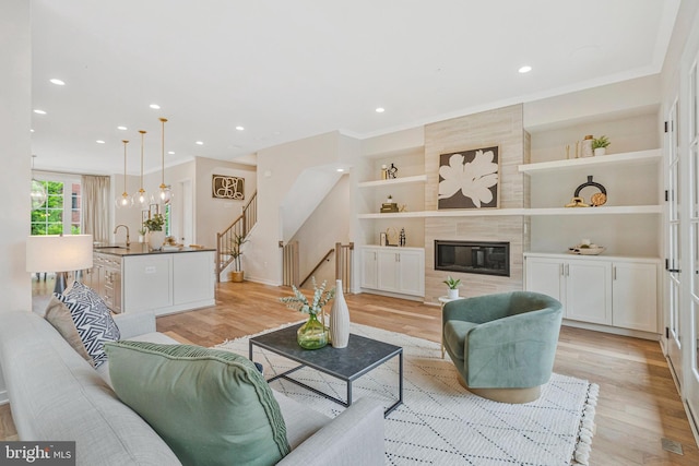 11724 Paysons Way, Reston, VA 20191 - living room featuring light wood-type flooring, stairway, built in shelves, recessed lighting, and a high end fireplace