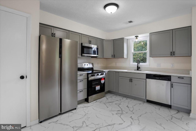 116 Somerset Dr, Stephens City, VA 22655 - kitchen featuring stainless steel appliances, gray cabinets, light marble finish flooring, a textured ceiling, and light countertops