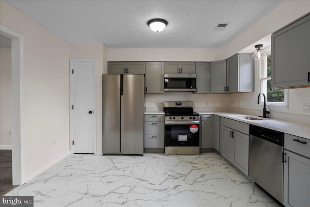 116 Somerset Dr, Stephens City, VA 22655 - kitchen featuring stainless steel appliances, gray cabinets, light marble finish flooring, light countertops, and a textured ceiling