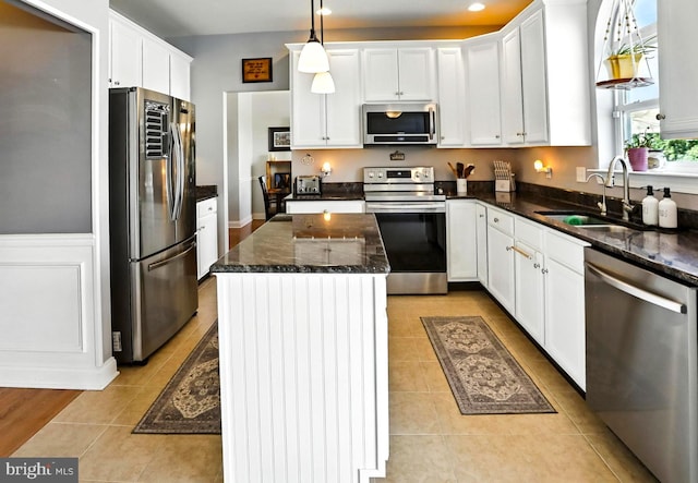 70 Marjessa Dr, Gilbertsville, PA 19525 - kitchen featuring appliances with stainless steel finishes, white cabinets, light tile patterned floors, a center island, and dark stone countertops