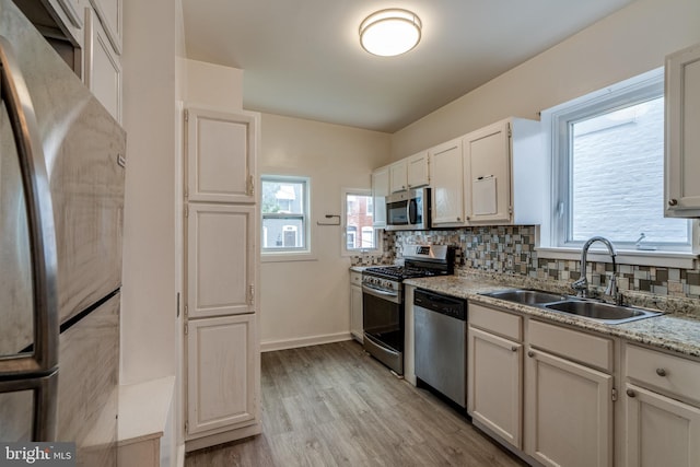 589 N Plum St, Lancaster, PA 17602 - kitchen with stainless steel appliances, backsplash, light wood finished floors, and light stone counters