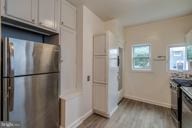 589 N Plum St, Lancaster, PA 17602 - kitchen featuring appliances with stainless steel finishes, light wood finished floors, white cabinets, and backsplash