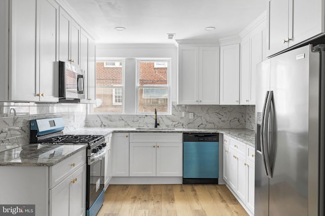913 E Sanger St, Philadelphia, PA 19124 - kitchen with stainless steel appliances, white cabinetry, tasteful backsplash, light wood-type flooring, and light stone countertops