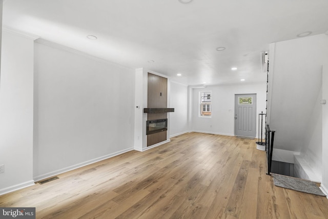 913 E Sanger St, Philadelphia, PA 19124 - unfurnished living room featuring light wood finished floors, a glass covered fireplace, recessed lighting, and ornamental molding