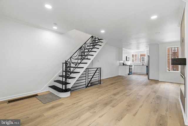 913 E Sanger St, Philadelphia, PA 19124 - unfurnished living room featuring light wood finished floors, recessed lighting, crown molding, and stairs