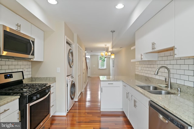3343 Paine St, Baltimore, MD 21211 - kitchen featuring stainless steel appliances, estacked washer and dryer, dark wood finished floors, a peninsula, and white cabinets