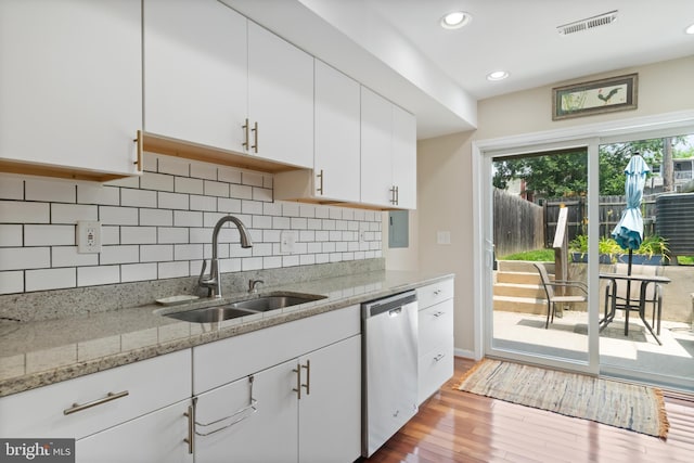 3343 Paine St, Baltimore, MD 21211 - kitchen with dishwasher, white cabinetry, wood finished floors, tasteful backsplash, and light stone counters