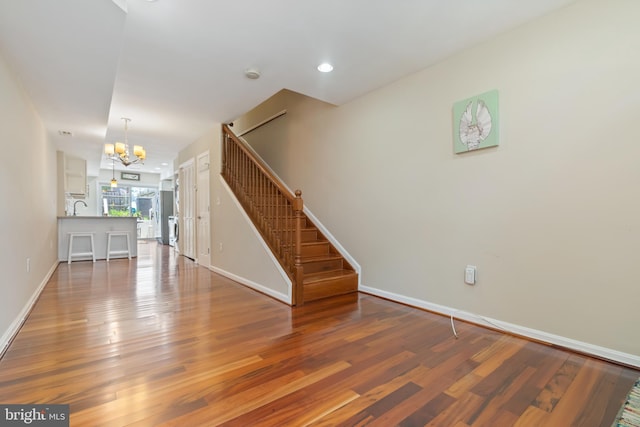 3343 Paine St, Baltimore, MD 21211 - unfurnished living room with a chandelier, stairway, and wood finished floors